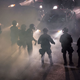 Smoke and tear gas fill the air around trapped drivers as police advance upon demonstrators after a rally by President Donald Trump at the Phoenix Convention Center on August 22, 2017, in Phoenix, Arizona. An earlier statement by the president that he was considering a pardon for Joe Arpaio, the former sheriff of Maricopa County who was convicted of criminal contempt of court for defying a court order in a case involving racial profiling, has angered Latinos and immigrant rights, advocates.